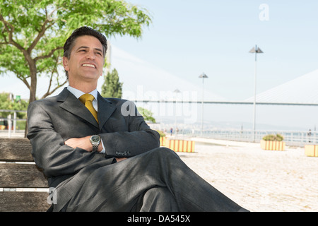 Businessman relaxing outdoors near the water Stock Photo