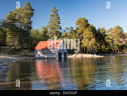 Dappled evening light on a boat house at Loch Vaa near Aviemore in the Cairngorms Stock Photo