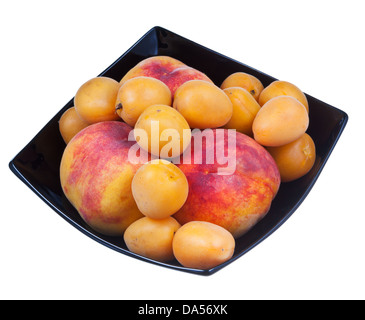 peaches and apricots in black plate isolated on white background Stock Photo
