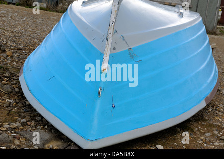 Blue rowing boat upside down on a beach Stock Photo