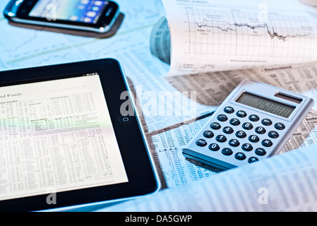 Stock prices in the newspaper and on the screen of a tablet computer. Stock Photo