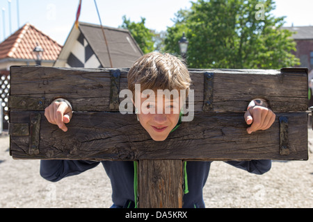 a boy trapped in a medieval torture device Stock Photo