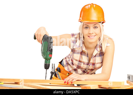 Female carpenter with helmet at work using hand drilling machine isolated on white background Stock Photo