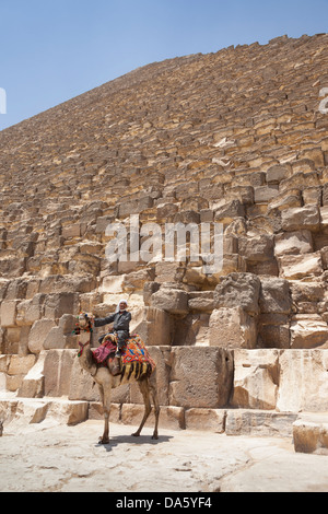 Man and camel beside Great Pyramid of Giza, also known as Pyramid of Khufu and Pyramid of Cheops, Giza, Cairo, Egypt Stock Photo