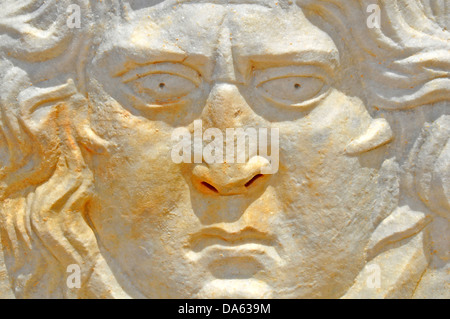 Face of a sad or angry man with long hair carved in marble, by an ancient roman sculptor Stock Photo