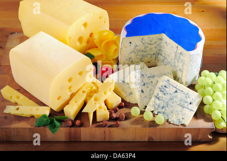 Various types of tasty cheese on cutting board Stock Photo