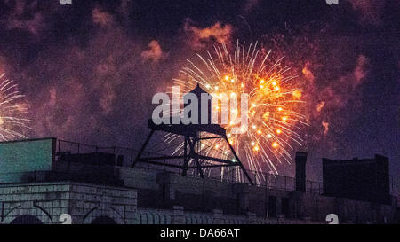 New York City, USA. 04th July, 2013. Brilliant color colors colour colours of Macy's spectacular annual fourth of July 04 4th patriotic holiday fireworks firework display lights light up the sky above Hudson River beyond city skyline of Hells Kitchen neighborhood & silhouetted form of old wooden water tower watertower. Credit:  Dorothy Alexander/Alamy Live News Stock Photo