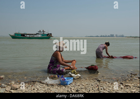 people washing clothes on the banks of Irrawaddy river near Mingun town Stock Photo