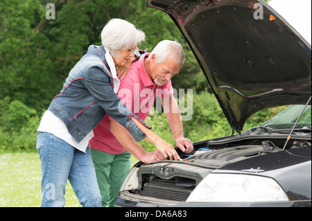 Senior couple standing together at a broken car Stock Photo