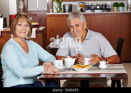 Happy senior couple sitting at breakfast in a hotel Stock Photo
