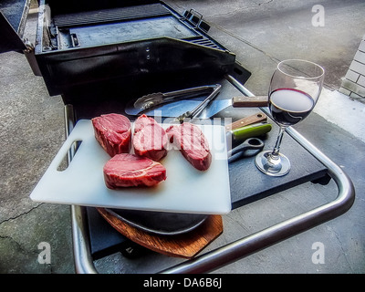 Red wine and steaks ready for a backyard barbecue in Australia. Stock Photo