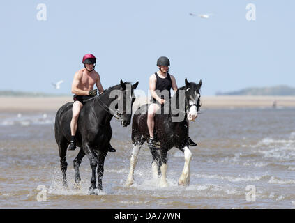 Holkham, UK. 04th July, 2013. The Household Cavalry Mounted Regiment on Holkham Beach. Members of The Household Cavalry Mounted Regiment and their horses enjoy the start of their summer camp in the sea and on the beach at Holkham in Norfolk. Pic: Paul Marriott Credit:  Paul Marriott/Alamy Live News Stock Photo