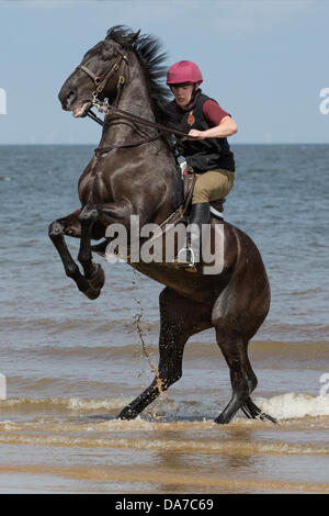 Holkham, Norfolk, UK. 4th July, 2013. The Household cavalry - A soldier of the  Lifeguards riding Warlord on Holkham beach in North Norfolk during their annual summer camp. Holkham. North Norfolk.England.04 July 2013 Credit:  David Osborn/Alamy Live News Stock Photo