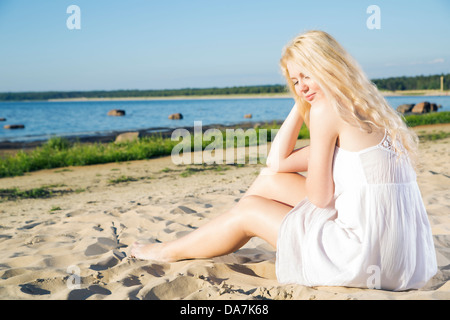 Woman in white dress indulgence on warm beach Stock Photo