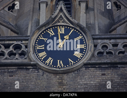 large well maintained Church Clock with black face and Gold hands viewed from below on a disused Church. Stock Photo