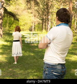 Divorce conflict separation concept, couple problems, unhappy woman (wife) going away from man (husband) outdoor in summer park Stock Photo