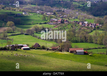 Bucolic landscape with hilly pastures, stone farmhouses, and cows grazing in Midi-Pyrenees region of France Stock Photo