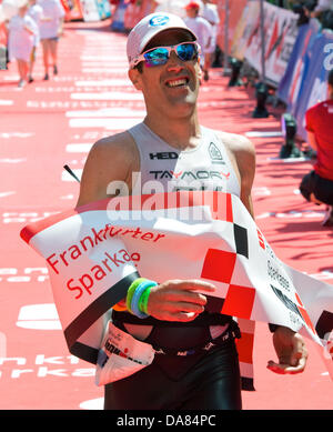 Frankfurt Main, Germany. 07th July, 2013. Eneko Llanos from Spain wins the Ironman in Frankfurt Main, Germany, 07 July 2013. The participants from 55 countries had to swim 3.8 km, cycle 180 km and run 42.195 km. Thousands of spectators attended the event. Photo: BORIS ROESSLER/dpa/Alamy Live News Stock Photo