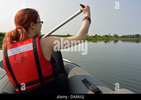 Young woman paddling a Sevylor Colorado Premium inflatable canoe on the River Great Ouse towards Ely, Cambridgeshire Stock Photo