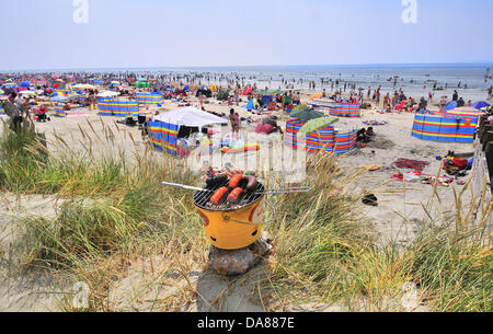 West Wittering, West Sussex, UK. 7th July, 2013. Sizzling Sunday as day-trippers take to the popular West Wittering beach to cool off as the temperatures rose to 30 degrees inland in southern England  2nd car park opened to accommodate up to 10.000 cars. iPhones and  iPads were at the ready to stream the Wimbledon tennis in  beach tents  and under umbrellas Credit:  Gary Blake/Alamy Live News Stock Photo