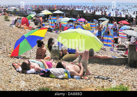 West Wittering, West Sussex, UK. 7th July, 2013. Sizzling Sunday as day-trippers take to the popular West Wittering beach to cool off as the temperatures rose to 30 degrees inland in southern England  2nd car park opened to accommodate up to 10.000 cars I Phones and  iPads were at the ready to stream the Wimbledon tennis,under in beach tents  and umbrellas Stock Photo