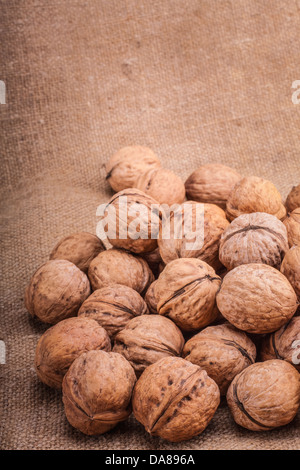 Unshelled walnut lying on sackcloth Stock Photo