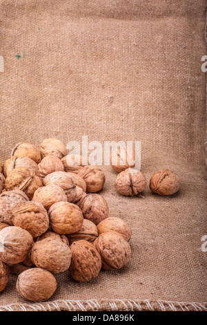 Unshelled walnut lying on sackcloth Stock Photo