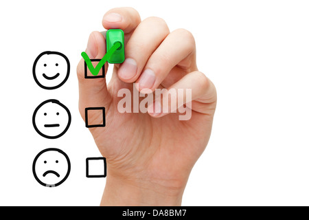 Hand putting check mark with green marker on customer service evaluation form. Stock Photo