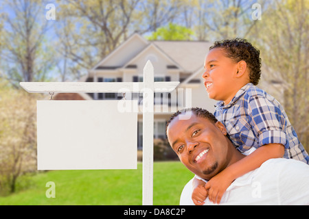 Happy African American Father and Mixed Race Son In Front of Blank Real Estate Sign and New House. Stock Photo