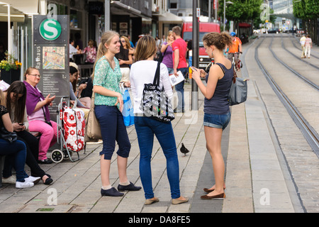 Summer in the city – Young women, female teenagers, waiting, chatting at a German tram station – Heilbronn, Germany Stock Photo