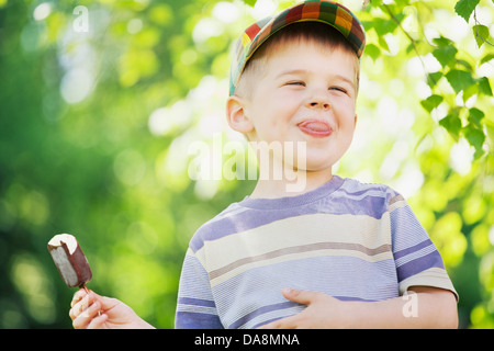 Cheerful small boy eating an ice cream Stock Photo