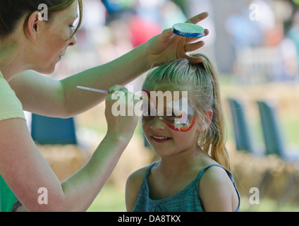 Young girl having her face painted Stock Photo