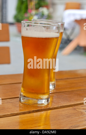 Glass of beer in restaurant on the table outdoor in the sun Stock Photo