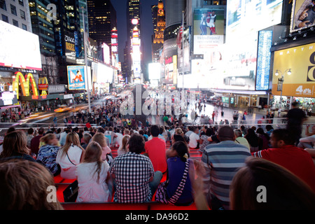 CROWD SITTING ON RED STEPS OF TKTS BOOTH TIMES SQUARE MIDTOWN MANHATTAN NEW YORK CITY USA Stock Photo