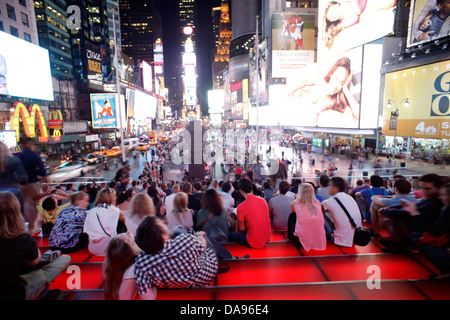 CROWD SITTING ON RED STEPS OF TKTS BOOTH TIMES SQUARE MIDTOWN MANHATTAN NEW YORK CITY USA Stock Photo