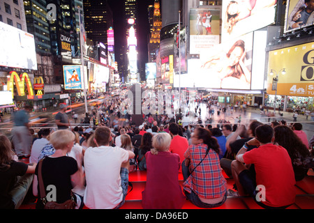 CROWD SITTING ON RED STEPS OF TKTS BOOTH TIMES SQUARE MIDTOWN MANHATTAN NEW YORK CITY USA Stock Photo