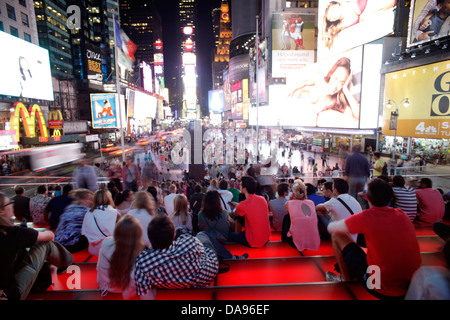 CROWD SITTING ON RED STEPS OF TKTS BOOTH TIMES SQUARE MIDTOWN MANHATTAN NEW YORK CITY USA Stock Photo