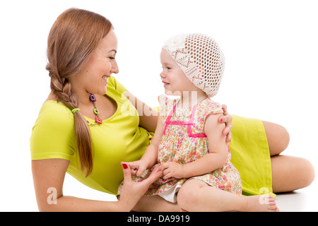 happy mother and little girl lying on white floor and smiling Stock Photo