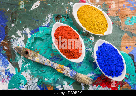 Vibrant color pigments in porcelain bowls on a wooden palette Stock Photo