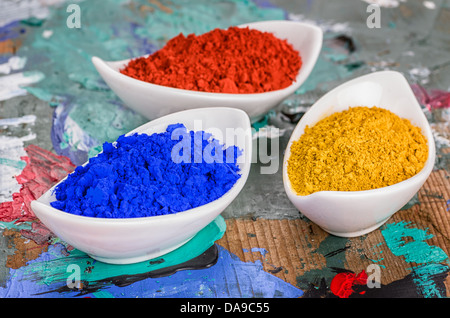 Vibrant color pigments in porcelain bowls on a wooden palette Stock Photo