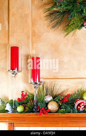 Christmas decorations with candles on the fireplace mantle. Stock Photo