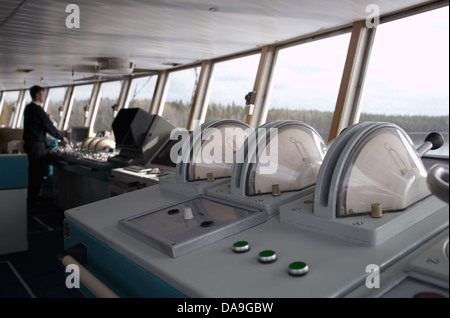 Navigational officer driving ship on the river. Stock Photo