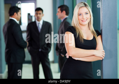 attractive blond corporate worker standing in office Stock Photo