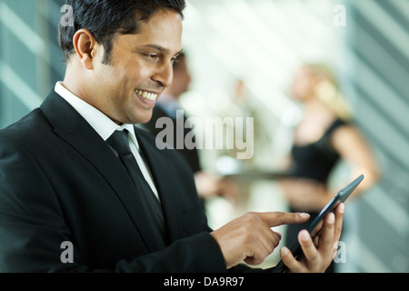 handsome Indian business executive working on tablet computer in office Stock Photo