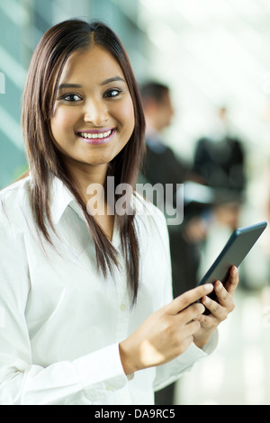 attractive Indian office worker holding tablet computer in office Stock Photo