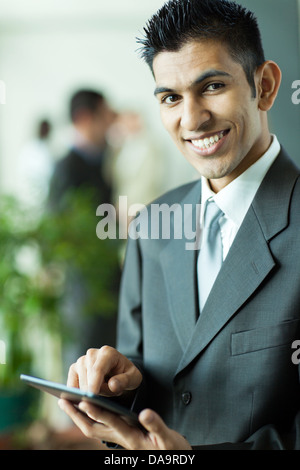 cheerful middle eastern businessman with tablet computer in office Stock Photo