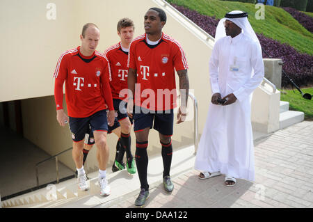 FC Bayern Munich's Arjen Robben (L-R), Thomas Mueller and Edson Braafheid arrive at a practice of a training camp in Doha, Qatar, 04 January 2011. FC Bayern Munich prepaires for the second half of the season 2010/2011 with a training camp that takes place between 02 and 09 January in Qatar. Photo: Andreas Gebert Stock Photo