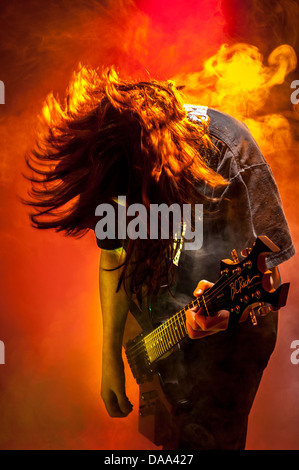 Unidentifiable young caucasian male musician playing guitar on stage. Stock Photo