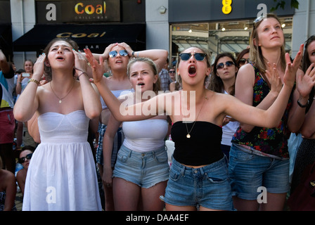 Emotions face unhappy  UK teenage teen girls sports fans watching live sport on outside huge television TV screen. Unhappy disbelief at the way the game is going, 2013 2010s England HOMER SYKES Stock Photo