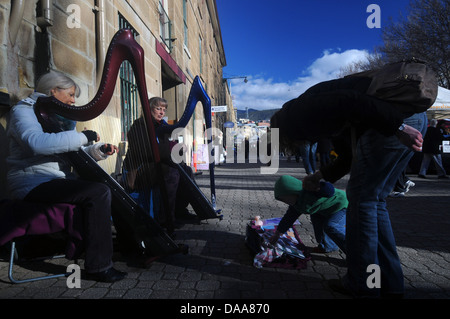 Busking women with harps playing on the street, Salamanca Markets, Hobart, Tasmania, Australia. No MR or PR Stock Photo